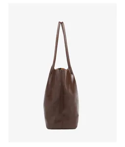 Side view of dark brown tote bag in glossy oil wax leather with stitching details