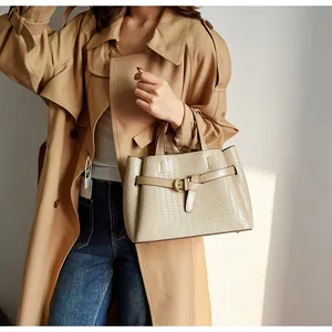 Detail of woven texture and gold buckle on a stylish large beige tote bag