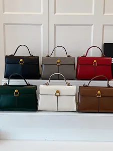 Sacs à main trapèze minimalistes en six couleurs sur un présentoir à plusieurs niveaux