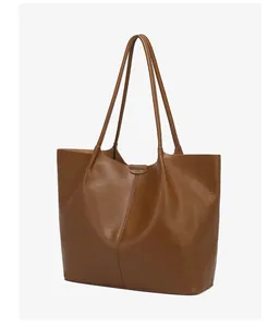 Detailed view of caramel leather tote bag with vertical stitching and smooth texture
