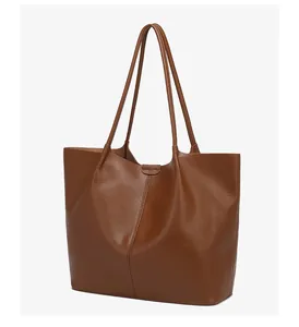 Detail view of large brown tote bag with premium leather texture and vertical stitching