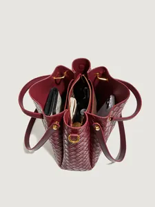 Sac seau bordeaux en cuir tressé avec un aménagement intérieur spacieux à trois compartiments