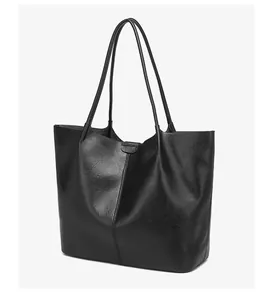 Detail of black tote bag featuring premium leather texture and vertical stitching accents