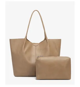 Detail view of khaki leather tote bag and matching small zipper pouch set on white background