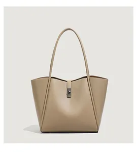 Detail van kaki tote bag in generfd leer met zilverkleurige draaisluiting en handvat