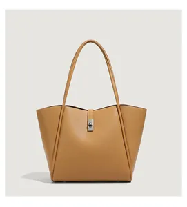 Detail van karamelkleurige shopper met lychee leerstructuur en zilveren draaislot