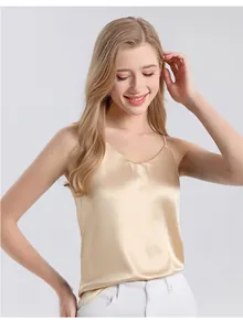 Detail of champagne silk camisole featuring thin straps and elegant V-neckline fabric