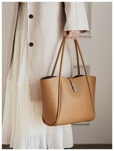 Detail van camel tote bag met zilveren draaisluiting en kunstleer met korrelstructuur