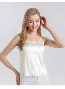Detail of a pearl white silk camisole featuring thin straps and smooth satin texture
