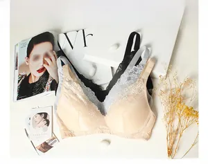 Flat lay of silk lace bras in beige, grey, and black colors with floral patterns
