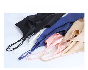Flat lay of silk camisole tops in black white blue pink and gold with thin straps