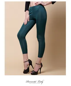 Detailed view of the dark green silk knit leggings showing the glossy elastic waist texture
