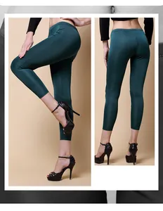 Detail showing the elastic waistband and slim fit of dark green silk knit trousers