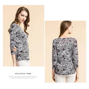 Detail view of abstract black floral print on a light blue silk knit top for women