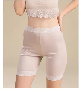 Close-up of silk knit safety shorts with delicate floral lace trim in apricot color