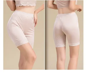 Detailed close-up of pink silk safety shorts featuring elegant lace edges and glossy texture