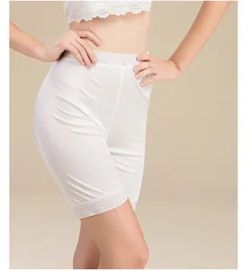 Detailed view of delicate lace trim on white silk knit safety shorts for women