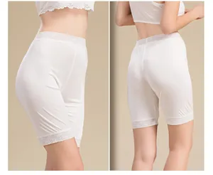 Detailed view of white silk safety shorts featuring delicate lace trim and seamless fabric