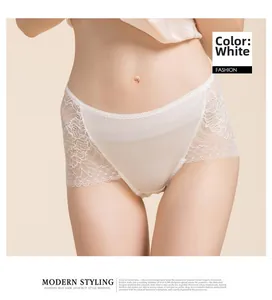 Close-up of white silk panties featuring elegant floral lace stitching and smooth satin fabric
