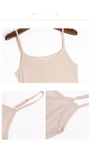 Detail view of adjustable spaghetti straps and smooth silk fabric texture on beige slip dress