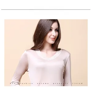 Detailed view of women's silk V-neck top with delicate lace trim in champagne