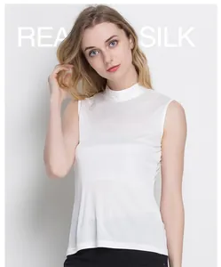 Detail of white sleeveless silk top with mock neck and natural pearlescent finish