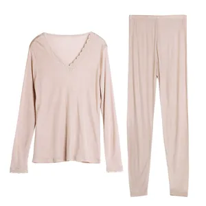 Women's silk thermal underwear set with V-neck lace trim and matching pants in champagne