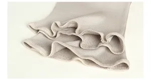 Detailed view of the ribbed knit fabric texture and elegant ruffled wavy edges on the waist warmer