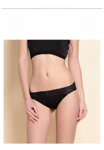 Detailed close-up of low-rise silk thong with intricate black lace trim and satin finish