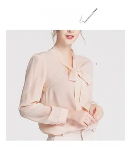 Detail of elegant apricot silk blouse with pussy-bow tie and smooth fabric texture