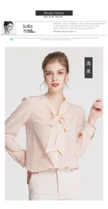 Detail of elegant beige silk shirt featuring a classic bow tie neckline and buttoned cuffs