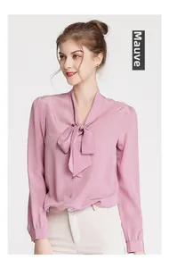 Detail of dusty pink silk blouse showing bow-tie collar and smooth satin fabric texture