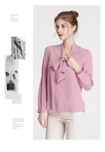 Detailed view of pink silk blouse with pussy-bow neck and elegant buttoned cuffs