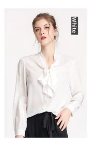 Close-up of elegant white silk shirt featuring a V-neck and a stylish bow-tie neckline