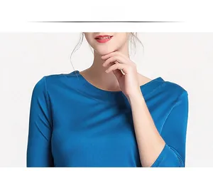 Close-up of elegant peacock blue silk knit top featuring a smooth boat neck and fine texture