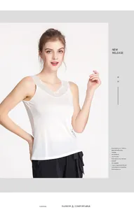 Close-up of elegant white silk camisole featuring delicate lace trim at the neckline