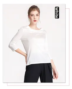 Detailed view of women's white silk blouse featuring a boat neck and smooth texture