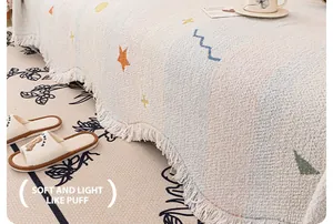 Dettaglio della trama a maglia della coperta color crema con stelle e frange bordate