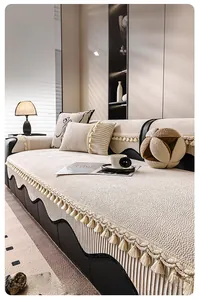 Detail of cream chenille sofa cover featuring elegant fringe edges and textured fabric