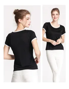 Détail de la bordure contrastée blanche sur le col et les manches du t-shirt en soie noire