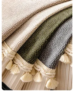 Close-up of thick textured sofa cover fabric with fringe tassels in multiple colors