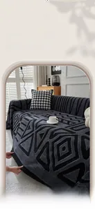 Detail of dark grey geometric chenille sofa cover with thick jacquard texture and fringes