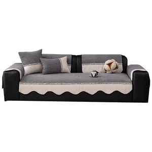 Modern grey checkered corduroy sofa cover set with scalloped edges on black leather sofa