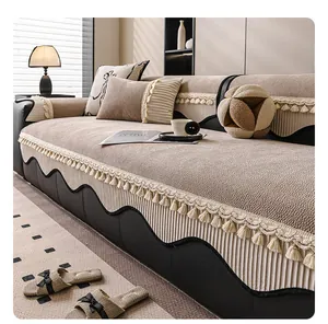 Detailed view of beige chenille sofa cover with fringe tassels and wavy black edge