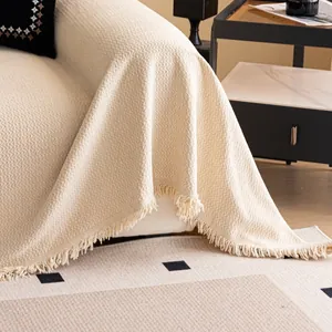 Beige wave textured chenille sofa cover with tassel trim in a modern home setting