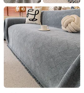 Close-up of grey chenille sofa cover with textured geometric patterns and fringe edges