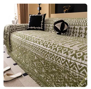 Detailaufnahme der olivgrünen Chenille-Sofadecke mit geometrischem Muster und Fransen