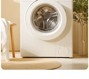 Front view of modern white front-load washing machine in a cozy home laundry setting