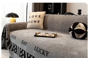 Détail du jeté de canapé en chenille gris clair avec motif jacquard Lucky Day
