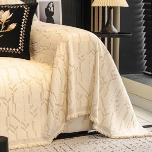 Copridivano beige stile francese con motivi geometrici e bordi decorati con frange